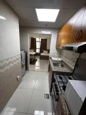 a kitchen with a stove and a living room at Cute Rooms and Small Partitions for Girls in Dubai- Female guests only فتيات فقط in Dubai