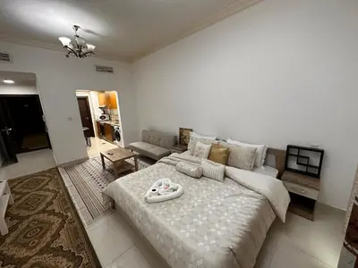 a bedroom with a large bed and a living room at Cute Rooms and Small Partitions for Girls in Dubai- Female guests only فتيات فقط in Dubai