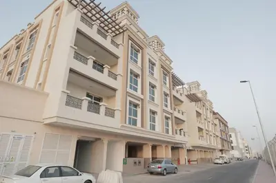 a large building with cars parked in front of it at Cute Rooms and Small Partitions for Girls in Dubai- Female guests only فتيات فقط in Dubai