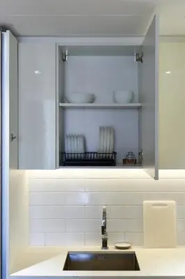 a kitchen with a sink and a shelf with dishes at New apt in Dubai Marina with balcony and sea view in Dubai