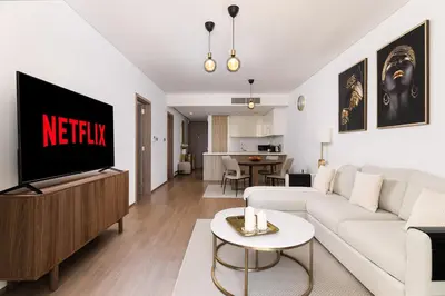 a living room with a white couch and a tv at New apt in Dubai Marina with balcony and sea view in Dubai