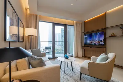 a living room with a couch and chairs and a tv at Premium 1BDR Apartment in Downtown Opera in Dubai