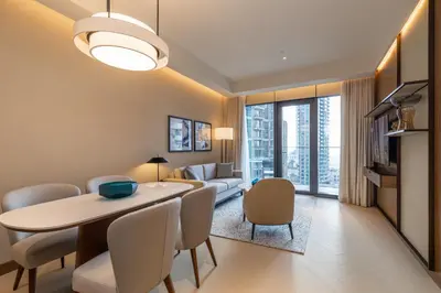 a dining room and living room with a table and chairs at Premium 1BDR Apartment in Downtown Opera in Dubai