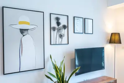 a living room with a tv and pictures on the wall at Prime Stylish Studio with Marina Views in Dubai