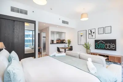 a bedroom with a white bed and a couch at Prime Stylish Studio with Marina Views in Dubai