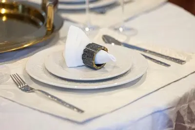 a table with a white plate with a napkin at The Suite Dubai 15 Northside Luxury Living in Dubai