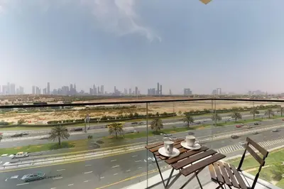 a balcony with a table and chairs and a highway at O Ten, Al Jaddaf - Smart One Bedroom in Dubai