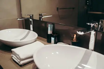 a bathroom with two white sinks and a mirror at Maison de Luxe - Jumeirah Living Marina Gate in Dubai