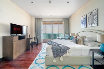 a hotel room with a bed and a television at GuestReady - Posh Living with Burj Al Arab view in Dubai