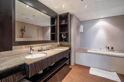 a bathroom with two sinks and a large mirror at GuestReady - Posh Living with Burj Al Arab view in Dubai