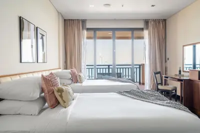 two beds in a hotel room with a balcony at GuestReady - Posh Living with Burj Al Arab view in Dubai
