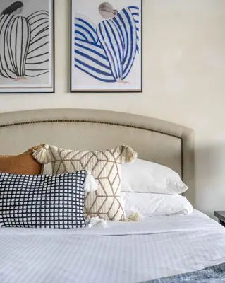 a bedroom with a bed with pillows and paintings on the wall at GuestReady - Burj Al Arab view at Royal Amwaj in Dubai