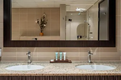 a bathroom with two sinks and a large mirror at GuestReady - Burj Al Arab view at Royal Amwaj in Dubai