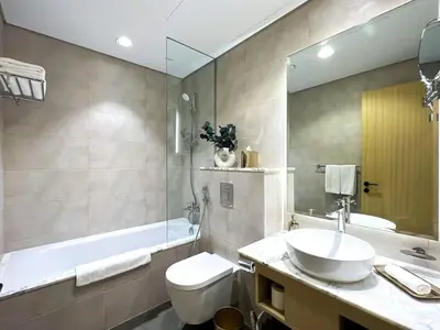 a bathroom with a sink and a toilet and a tub at Keyrock Living - Burj Khalifa View Retreat with Pool in Dubai