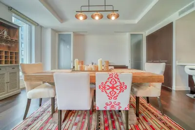 a dining room with a wooden table and white chairs at Limestone House, Dubai International Financial Centre - Mint Stay in Dubai