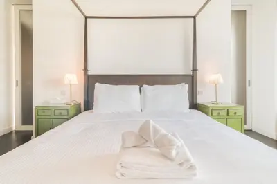 a bedroom with a large white bed with green night stands at Limestone House, Dubai International Financial Centre - Mint Stay in Dubai
