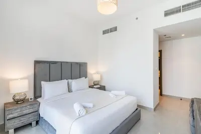 a bedroom with a large white bed with white pillows at Spacious 2 Bedroom on High Floor in Creek Horizon - Allsopp&Allsopp in Dubai