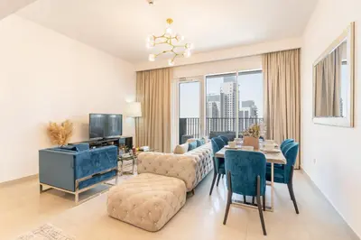 a living room with a couch and a table with chairs at Spacious 2 Bedroom on High Floor in Creek Horizon - Allsopp&Allsopp in Dubai
