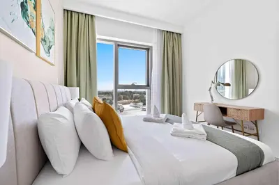 a white bedroom with a large bed with a window at Silkhaus furnished 1BDR in Downtown new tower in Dubai