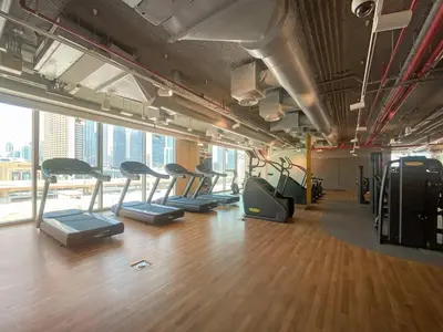 a gym with a row of treadmills in a room at Silkhaus furnished 1BDR in Downtown new tower in Dubai