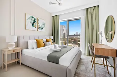 a bedroom with a bed and a desk and a window at Silkhaus furnished 1BDR in Downtown new tower in Dubai