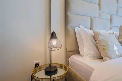 a lamp on a table next to a bed at AXINITE - Brand New! Warm Cozy 1 Bed HIGH FLOOR Downtown Dubai CANAL VIEW in Dubai