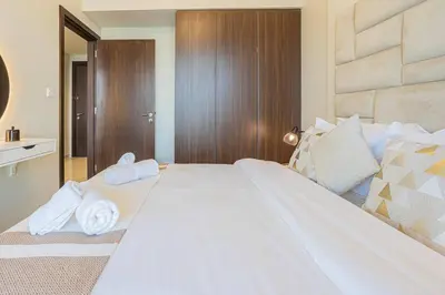 a bedroom with a large white bed with towels on it at AXINITE - Brand New! Warm Cozy 1 Bed HIGH FLOOR Downtown Dubai CANAL VIEW in Dubai