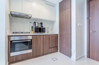 a kitchen with a stove and a microwave at Reva Residences - One Bedroom Apartment by the S Holiday Homes in Dubai