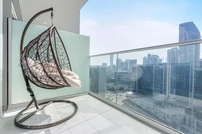 a hammock in a room with a view of a city at Reva Residences - One Bedroom Apartment by the S Holiday Homes in Dubai