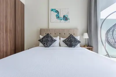 a bedroom with a large white bed with pillows at Reva Residences - One Bedroom Apartment by the S Holiday Homes in Dubai