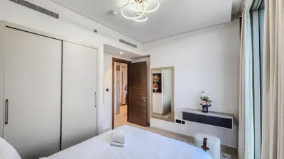 a white room with a bed and a mirror at STAY BY LATINEM Luxury 2BR Holiday Home CV B601 near Burj Khalifa in Dubai