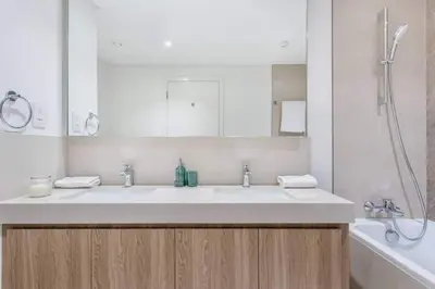 a bathroom with a sink and a mirror and a tub at 3BR facing Dubai Mall 5 min walk to Burj Khalifa in Dubai