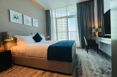a hotel room with a bed and a desk and a window at Canal View, Luxurious Studio In Downtown Dubai in Dubai