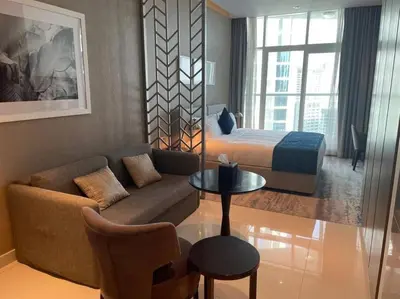 a living room with a couch and a bed at Canal View, Luxurious Studio In Downtown Dubai in Dubai