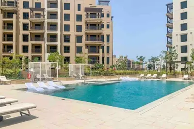a swimming pool with chairs and a building at Spacious 2 bedroom in Madinat Jumeirah Living in Dubai