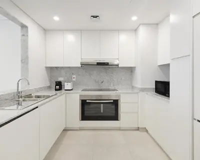 a white kitchen with white cabinets and a sink at Spacious 2 bedroom in Madinat Jumeirah Living in Dubai