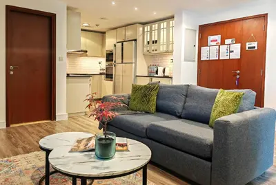 a living room with a couch and two tables at La Buena Vida Holiday Homes - Deluxe, very spacious 5 Bedroom plus maidroom in Best location of JBR, Near to Beach, Marina and Tram station in Dubai