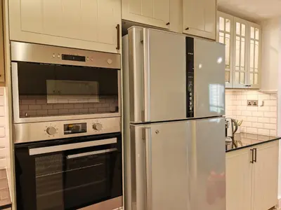 a kitchen with a stainless steel refrigerator and an oven at La Buena Vida Holiday Homes - Deluxe, very spacious 5 Bedroom plus maidroom in Best location of JBR, Near to Beach, Marina and Tram station in Dubai