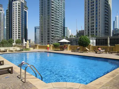 a large swimming pool in a city with tall buildings at La Buena Vida Holiday Homes - Deluxe, very spacious 5 Bedroom plus maidroom in Best location of JBR, Near to Beach, Marina and Tram station in Dubai