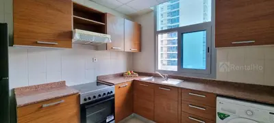 a kitchen with wooden cabinets and a sink and a window at 50% OFF Summer Offert, Nice w/ Balcony & Pool View in Dubai