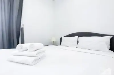 a bedroom with a white bed with towels on it at Cozy Spacious Studio With Balcony Dubai in Dubai