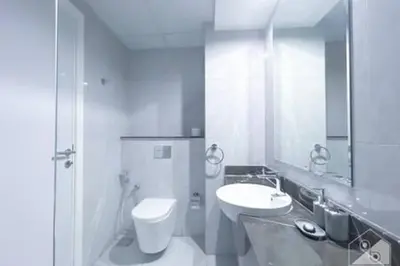 a white bathroom with a sink and a toilet at Cozy Spacious Studio With Balcony Dubai in Dubai