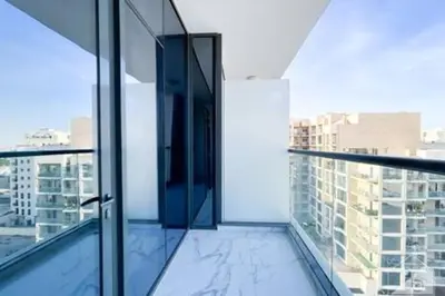 a glass balcony with a view of a city at Cozy Spacious Studio With Balcony Dubai in Dubai