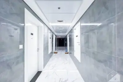 a hallway with white walls and a long corridor at Cozy Spacious Studio With Balcony Dubai in Dubai