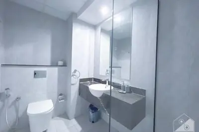 a white bathroom with a toilet and a sink at Cozy Spacious Studio With Balcony Dubai in Dubai
