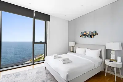 a bedroom with a large white bed and a large window at New 2 bedroom in Bluewaters with Direct Sea View in Dubai