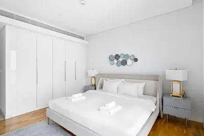 a white bedroom with a large white bed with white pillows at New 2 bedroom in Bluewaters with Direct Sea View in Dubai