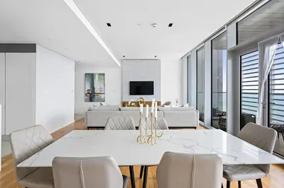 a dining room with a white table and chairs at New 2 bedroom in Bluewaters with Direct Sea View in Dubai
