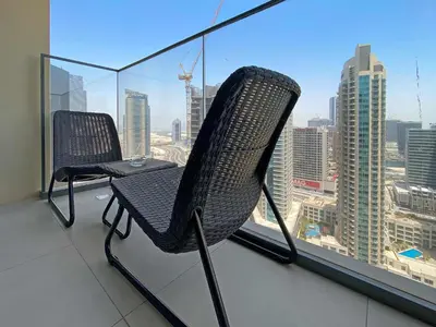 two chairs on a balcony with a view of a city at Silkhaus in Burj Royale, stunning 1BR in Downtown premium tower in Dubai