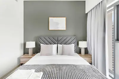 a bedroom with a large bed with two lamps at Silkhaus in Burj Royale, stunning 1BR in Downtown premium tower in Dubai